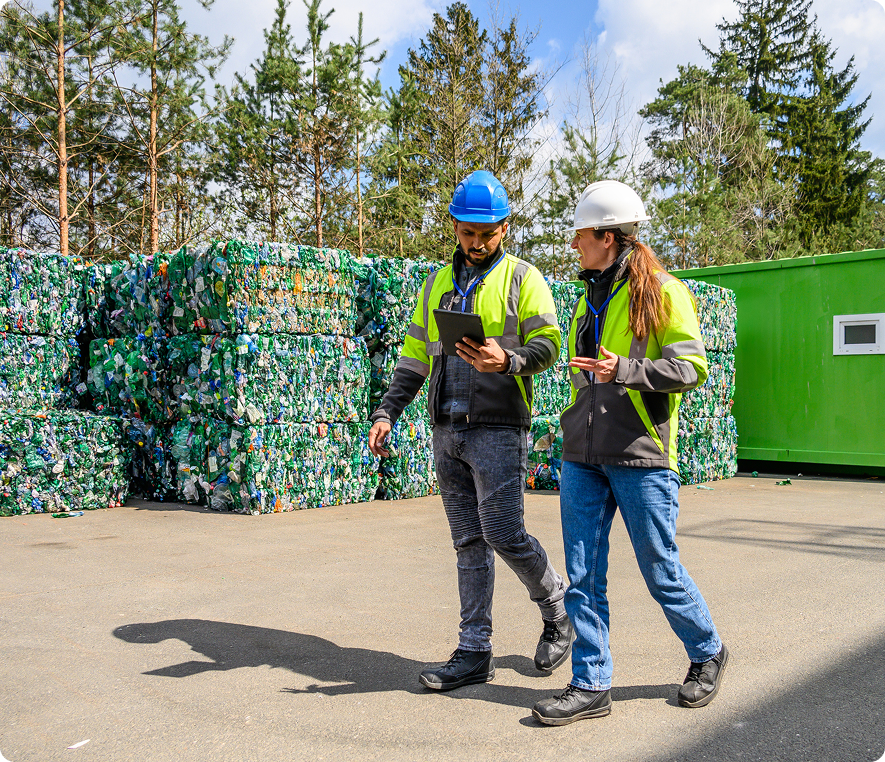 Recycling plant workers discussing operations